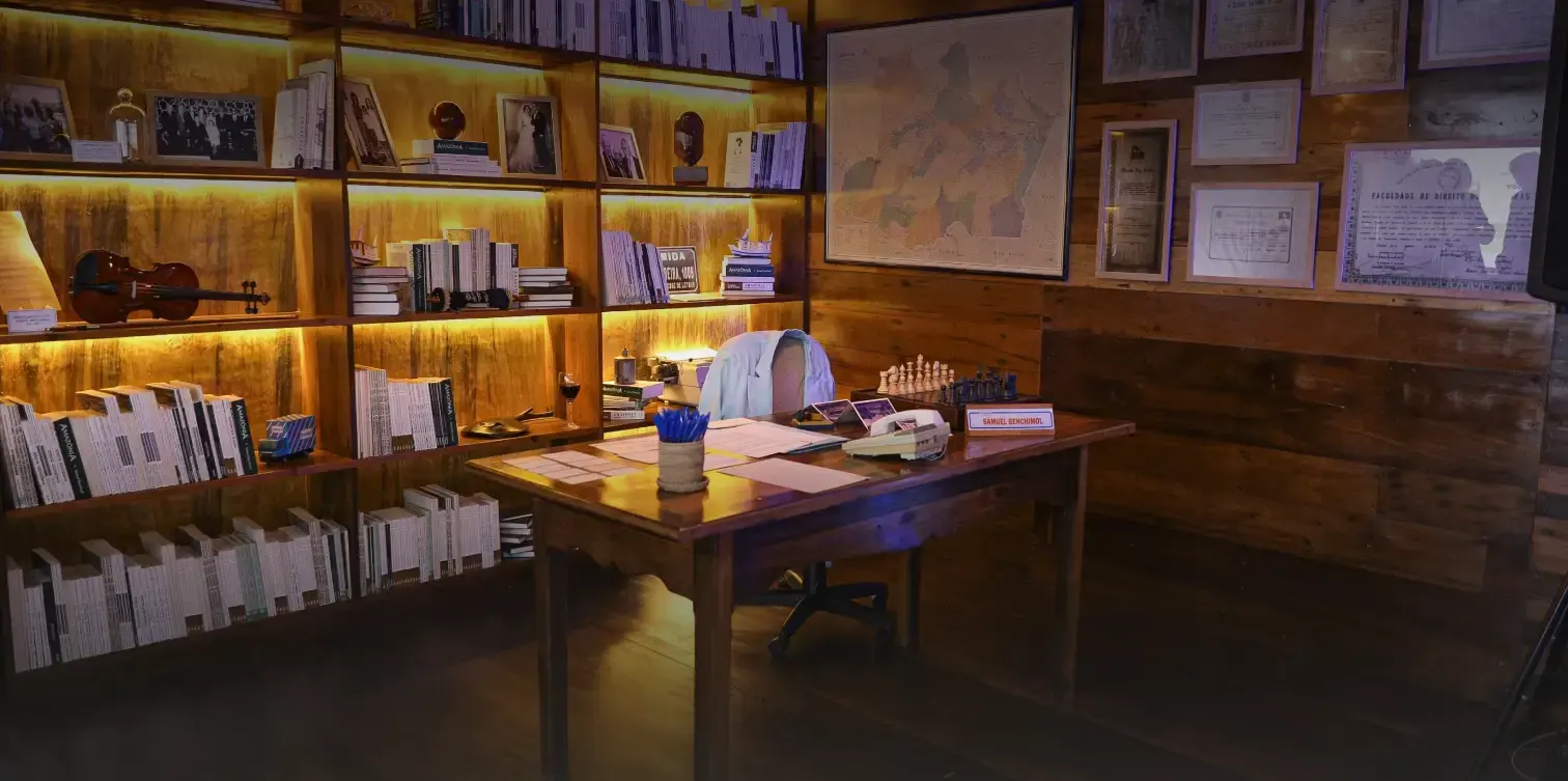 Escritório reproduzido no Memorial, com estantes iluminadas e mesa de trabalho de madeira